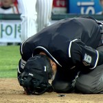 Korean umpire takes foul tip to the most sensitive area, leaves on a stretcher
