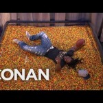 Marshawn Lynch leaps into a tank full of Skittles on Conan’s show